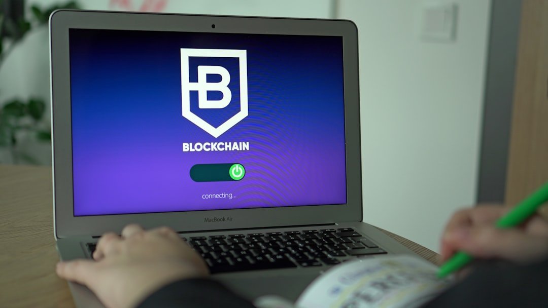 Pessoa usando um laptop exibindo o logotipo da blockchain na tela