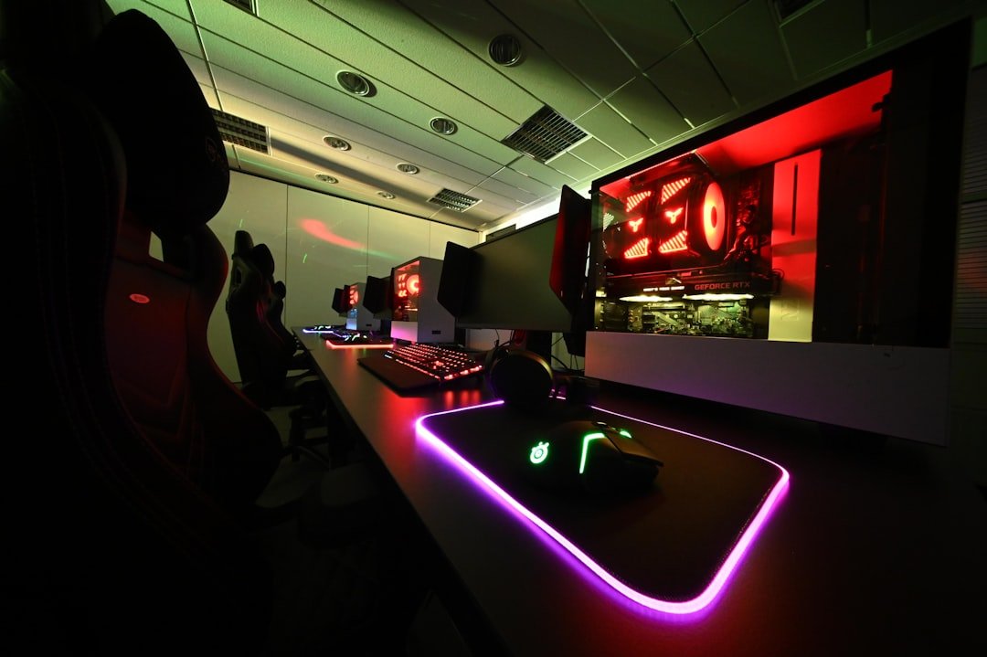 Gaming desk setup with neon lights glowing in dark room