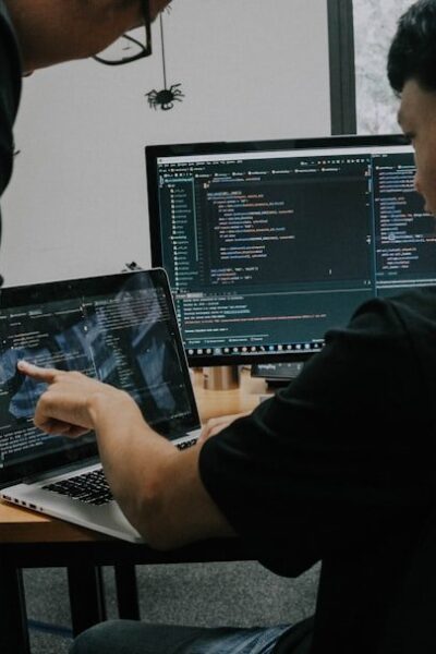 Two men working on computers at desks in an office setting