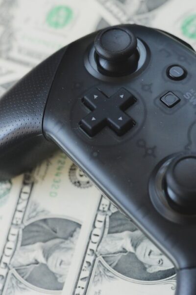 Video game controller resting on scattered dollar bills