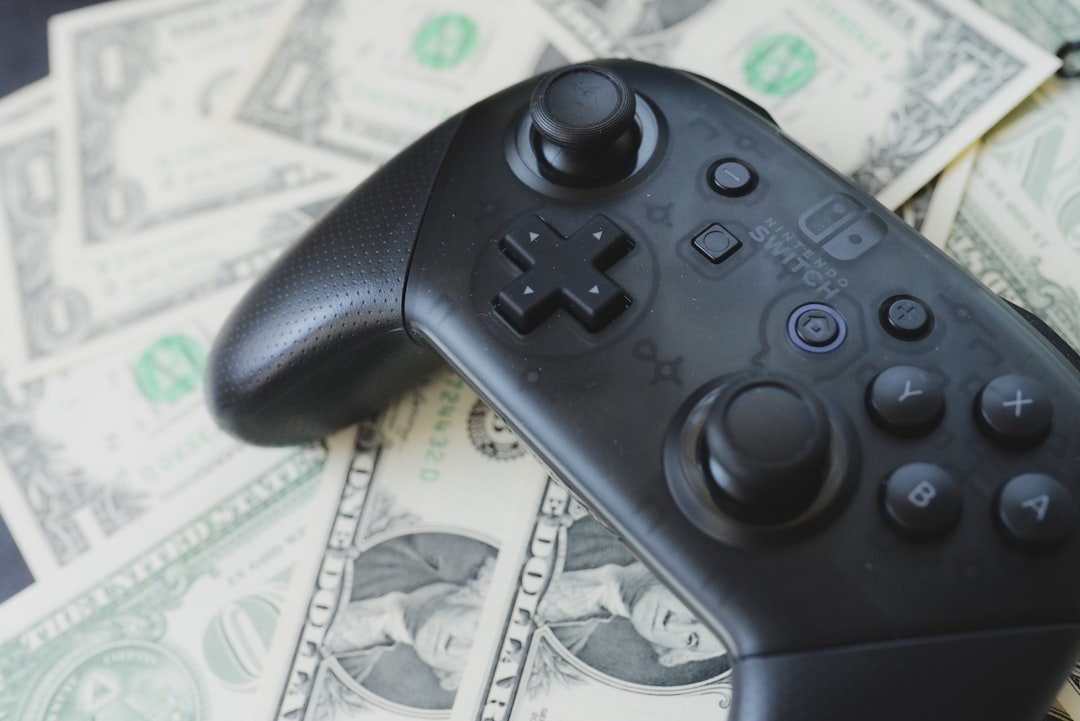 Video game controller resting on scattered dollar bills